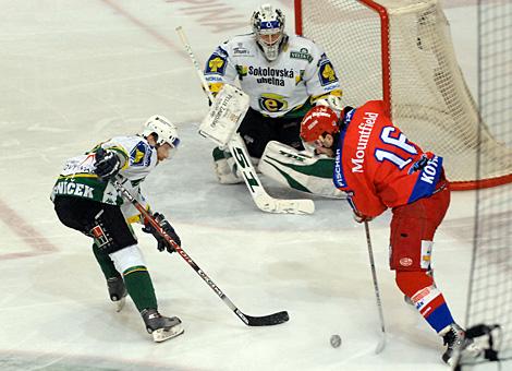 #16 Jindrich Kotrla, Stuermer, HC Mountfield Budweis, vor dem Tor des HC Energie Karlovy Vary, gehuetet von Lukas Mensator und bedraengt von der #9 Josef Reznicek, HC Energie Karlovy Vary.