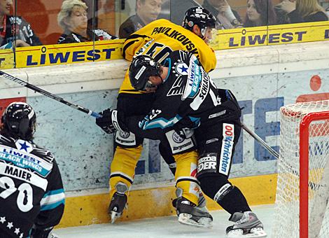 #63 Markus Schlacher, Stuermer, EHC Liwest Black Wings Linz kaempft mit der #50 Richard Pavlikovsky, Verteidiger, Krefeld Pinguine, an der Band um den Puck.