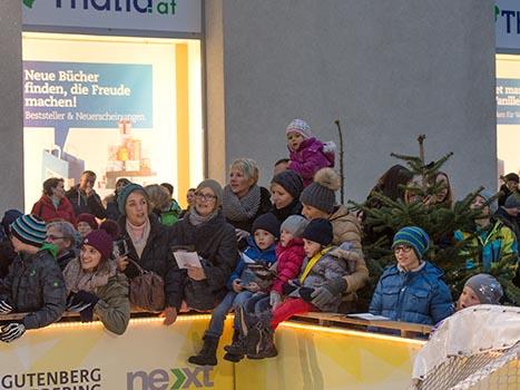 Fans und Kinder beim Adventsingen der Liwest Black Wings Linz  am Martin Lutherplatz in Linz.