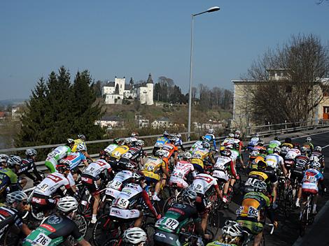 Das Hauptfeld in Wilhering Radsport, im Hintergrund Schloss Ottensheim