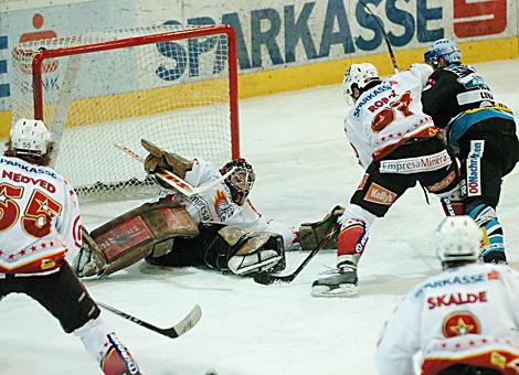 #71 Pat Leahy, Stuermer, EHC Liwest Black Wings Linz vor dem Tor der Slowenen. #33 Robert Kristan, Tormann und #37 Mitja Robar, versuchen in zu blocken.   