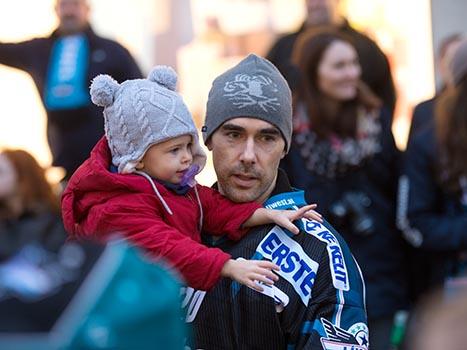 Brad Moran mit seiner Tochter, Adventsingen der Liwest Black Wings Linz  am Martin Lutherplatz in Linz.