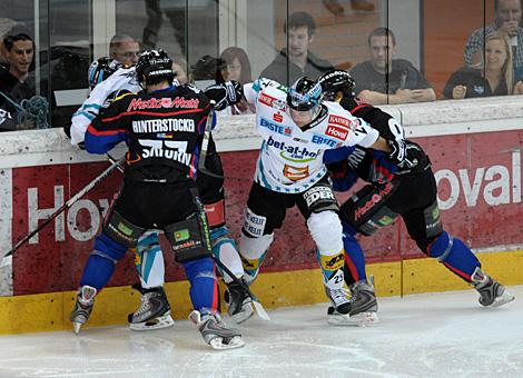 Daniel Oberkofler und Mark Szuecs, Liwest Black Wings Linz kaempfen an der Bande gegen Martin Hinterstocker, ERC Ingolstadt.