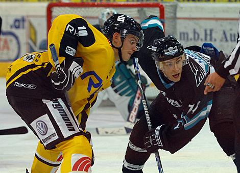 #74 Daniel Oberkofler, Stuermer, EHC Liwest Black Wings Linz beim Bully mit dem Krefelder #10 Andreas Driendl, Krefelder Pinguine.