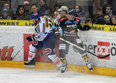 #91 Martin Grabher - Meier, Stuermer, EHC Liwest Black Wings Linz im Duell an der Bande mit der #14 Justin Mapletoft, EC Pasut VSV.