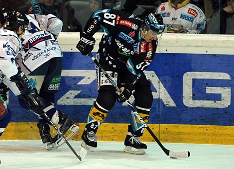 #87 Winfried Rac, Stuermer, EHC Liwest Black Wings Linz im Duell um die Scheibe an der Bande.