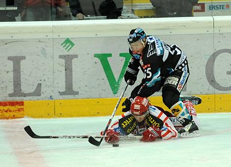 #55 Robert Lukas, Liwest Black Wings Linz, zwingt die #39 Jeff Shantz, KAC auf das Eis.