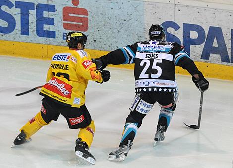 #25 Mark Szuecs, Stuermer, Liwest Black Wings Linz im Duell mit der #28 Dan Bjornlie, Verteidiger, Vienna Capitals.