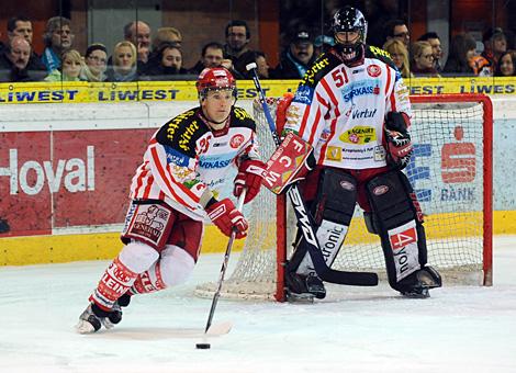 #25 Kirk Furey, Verteidiger, KAC, an der Scheibe. Im Hintergrund der Tormann #51 Travis Scott, KAC. 