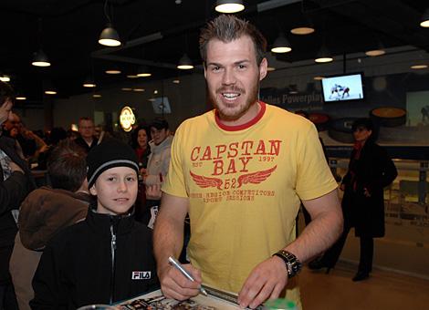 Michael Mayr, Verteidiger, Liwest Black Wings Linz schreibt Autogramme fuer einen jungen Fan.